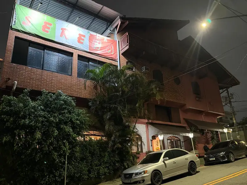 Fachada da Pizzaria Serena à noite, com o letreiro verde, branco e vermelho, na R. Duque de Caxias, 261, Vila Guarani, Mauá